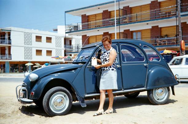 Costa Daurada (unfortunately the exact location is unknown), Catalonia, Spain, 1973. A vacationer has been given her rental car with the relevant vehicle documents.