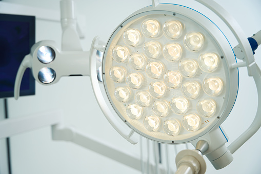 Round surgical lamp for dental chair. monitor in the background. Modern dental equipment