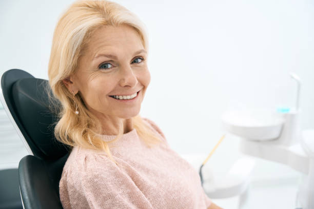 pretty patient looking with smile in dental clinic - dentists chair fotos imagens e fotografias de stock