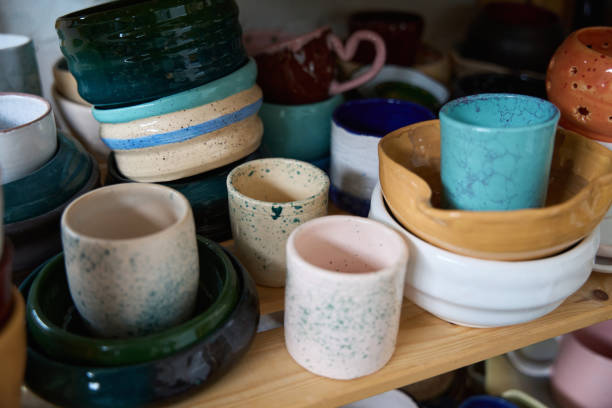 istock Multi-colored clay cups and bowls are stacked on wooden shelves 1432692581