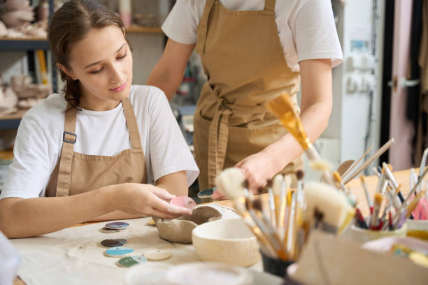 istock Student holds sample of paint for clay products in her hands 1432692606