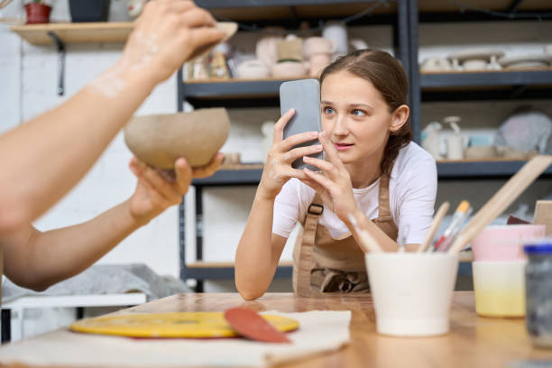 istock Student shoots colleague with pot in her hands on phone camera 1432692623