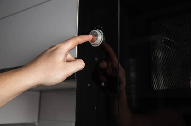 istock A man's hand presses a button-regulator on a modern microwave oven child protection, close-up. Copy space for text 1432697414