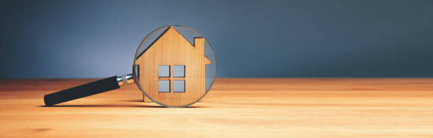 istock Wooden house and magnifying glass 1432698808