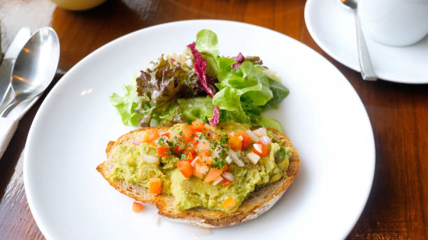 istock Healthy breakfast with avocado on sliced bread with tomatoes in cafe 1432699503