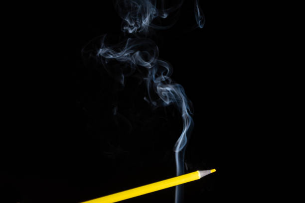 istock A yellow colored pencil touching the white smoke coming from below. 1432701695