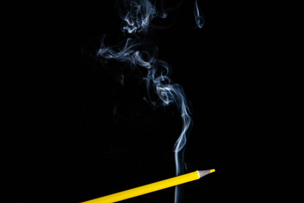 istock A yellow colored pencil touching the white smoke coming from below. 1432701700