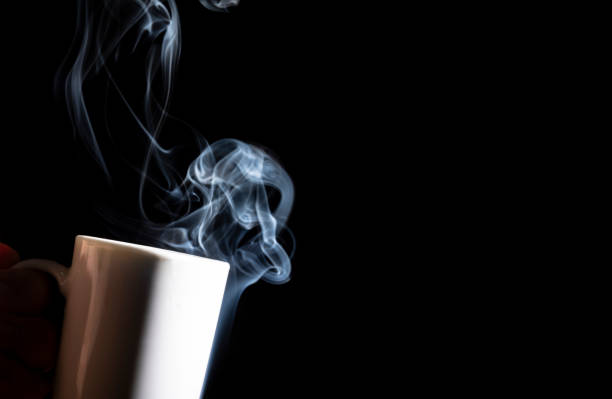 istock A white cup against a black background with smoke coming out of it. 1432701712