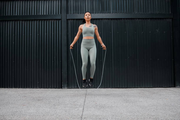 istock One young african american female athlete skipping using jump rope while exercising outside in the city. Beautiful and dedicated mixed race sportswoman working out alone against an urban background 1432701731