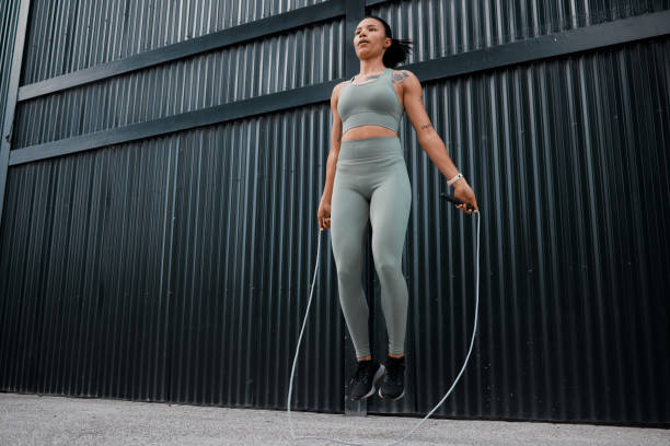 istock One young african american female athlete skipping using jump rope while exercising outside in the city. Beautiful and dedicated mixed race sportswoman working out alone against an urban background 1432701736