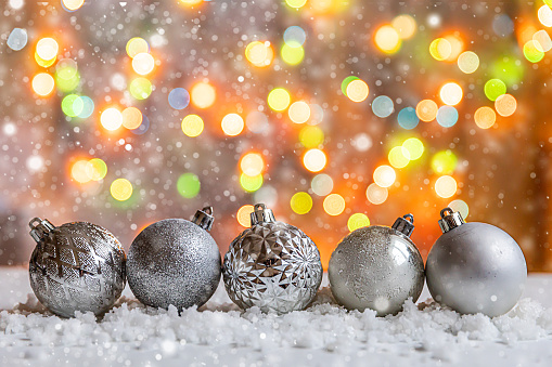 Abstract Advent Christmas Background. Winter decorations ornaments balls on background with snow and defocused garland lights. Merry Christmas time concept