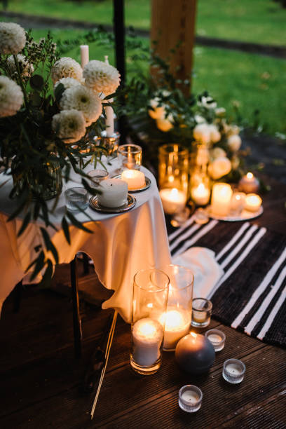 istock Romantic candlelight dinner at terrace restaurant at night. Location for surprise marriage proposal. A place for date or engagement in park in a tent and decorated with candles and garlands. Closeup. 1432703217