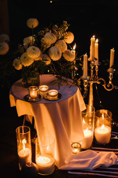 istock Romantic candlelight dinner at terrace restaurant at night. Location for surprise marriage proposal. A place for date or engagement in park in a tent and decorated with candles and garlands. Closeup. 1432703221