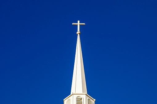 White cross on top of a steeple with copy space