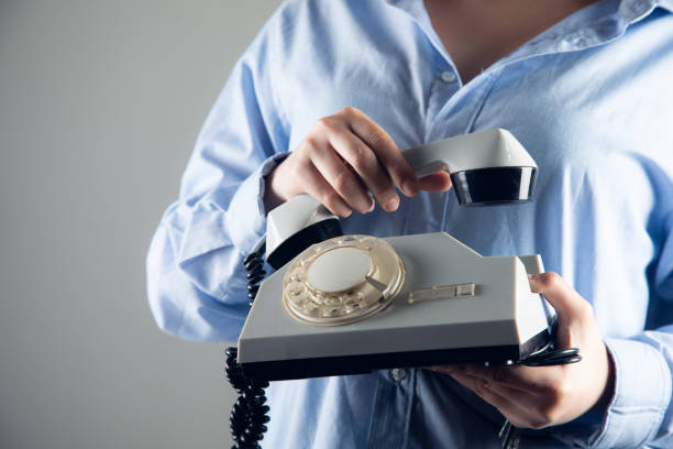 istock woman hand corded phone. 1432706901