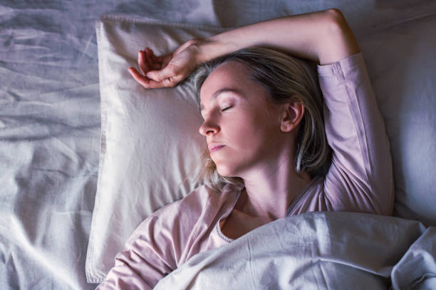 istock Middle aged woman sleeping in cozy bed 1432706959