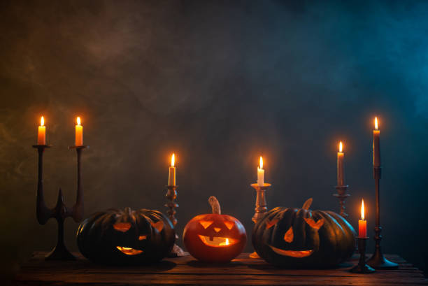 istock halloween pumpkins with burning candles on dark background 1432707587