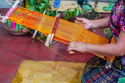 Closeup view of a Guatemalan Indigenous woman working in a traditional and typical handmade textile