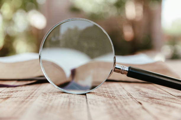 istock Book and magnifier on wooden table 1432709722