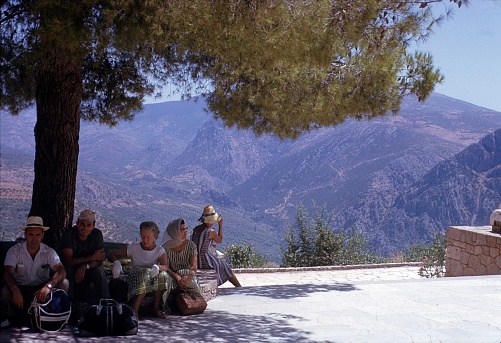 Olympia, Peloponnese, Greece, 1967. Tourists take a rest in the shade of a tree at the ancient Olympia.