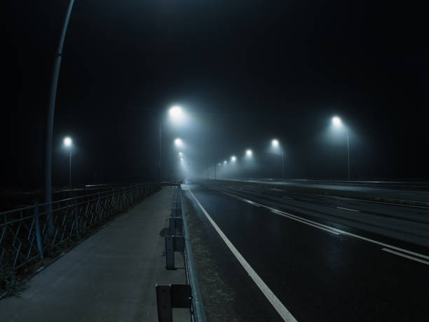 istock thick night fog on a lighted highway . dangerous road conditions 1432710878