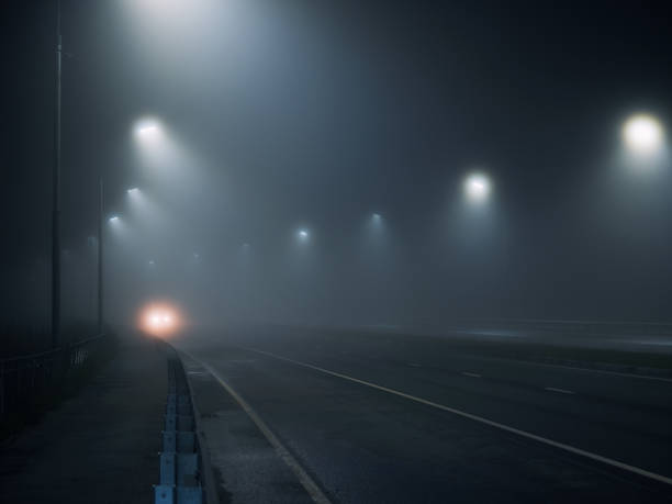 istock foggy road. night highway illuminated by lanterns 1432710884
