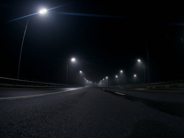 istock thick night fog on a lighted highway . dangerous road conditions 1432710885