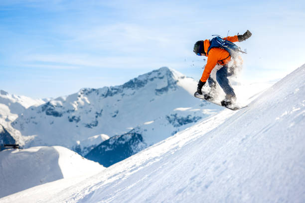 лыжник в действии в бэккантри со свежим порошковым снегом на горнолыжном курорте уистлер-блэккомб - snowboarding extreme sports snowboard winter стоковые фото и изображения