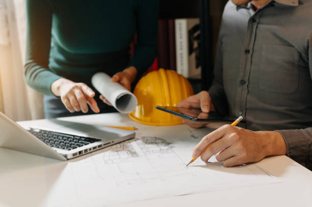 istock Two colleagues discussing data working and tablet, laptop with on on architectural project at construction site 1432713386