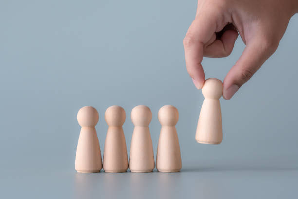 Wooden human figures leadership concept standing out from others