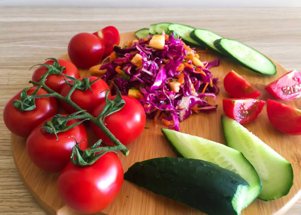 istock Salad and cherry tomatoes on a wooden board, view from above 1432714529