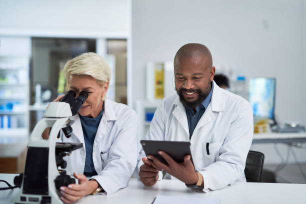 istock Microscope, digital tablet and scientists doing research on medical innovation in pharmaceutical lab. Collaboration, science development and experts working with biotechnology equipment in laboratory 1432720082