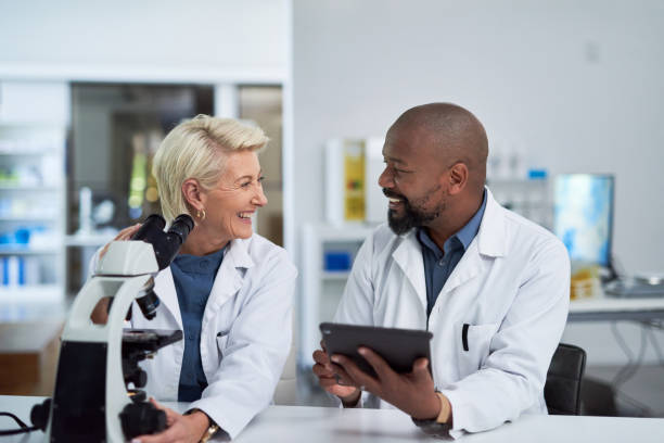 istock Research laboratory and science talk about tablet update for medical innovation and study. Happy, excited and professional scientist team discuss medicine news together on break in office. 1432720087