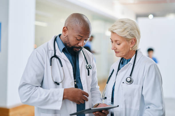 istock Web, tablet and doctors planning medical schedule on technology together at a hospital. Senior healthcare employees talking about surgery results, solution to health problem and strategy at clinic 1432720132