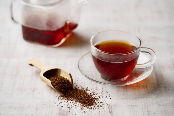 thé rooibos chaud dans une tasse et feuilles de thé. - rooibos tea red indoors still life photos et images de collection