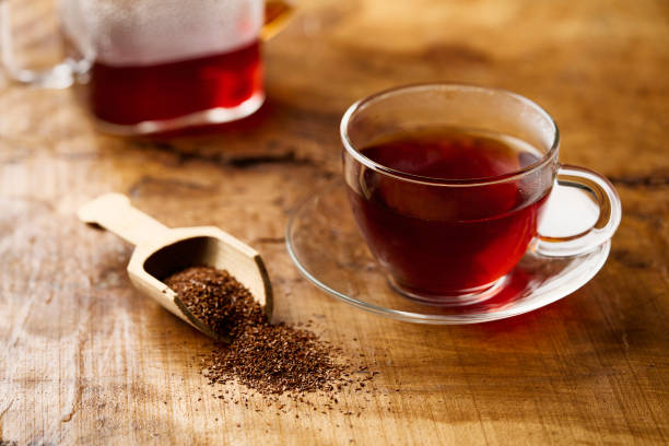 thé rooibos chaud dans une tasse et feuilles de thé. - rooibos tea red indoors still life photos et images de collection