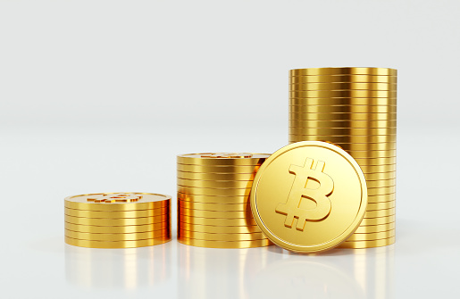 Three stacks of gold bitcoin cryptocurrency coins arranged like a bar graph or bar chart illustrating an upward trend, on a white background