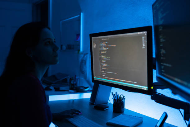 woman programming software codes overnight stock photo