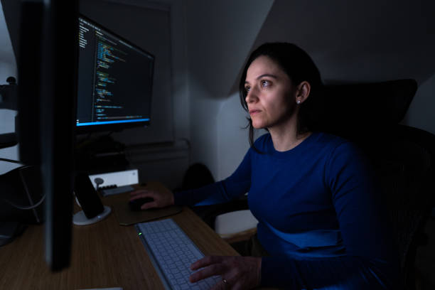 woman programming software codes overnight stock photo