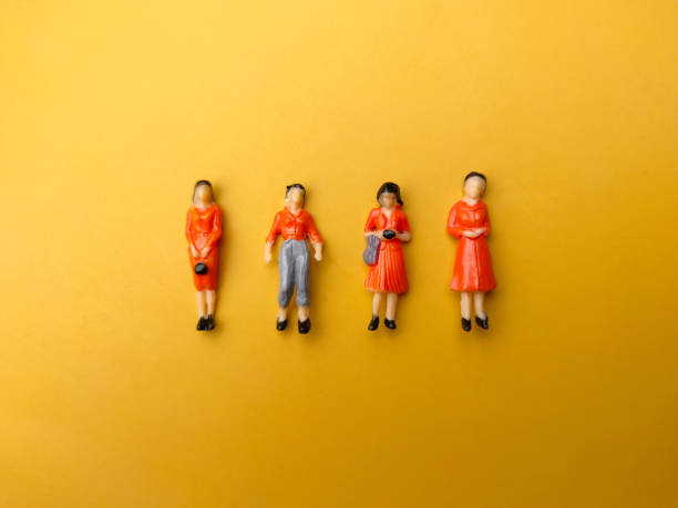 istock Miniature people are neatly arranged on a yellow background. 1432728933