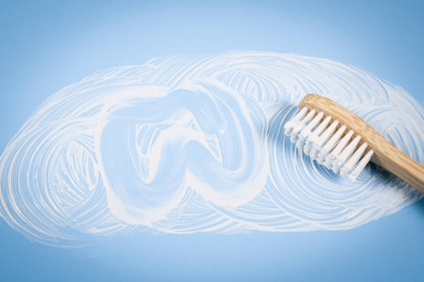 istock Bamboo toothbrush with smeared toothpaste and a painted tooth on a soft blue background 1432733520