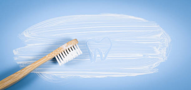 istock Bamboo toothbrush with smeared toothpaste and a painted tooth on a soft blue background 1432733523