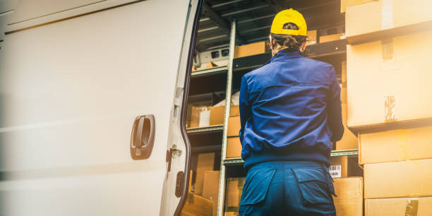 istock Female courier in professional blue uniform unloading delivery truck, back view 1432735215