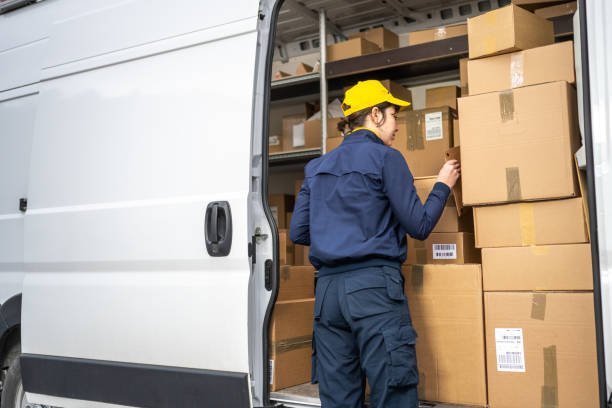 istock Courier in professional uniform unloading delivery truck, back view 1432735223
