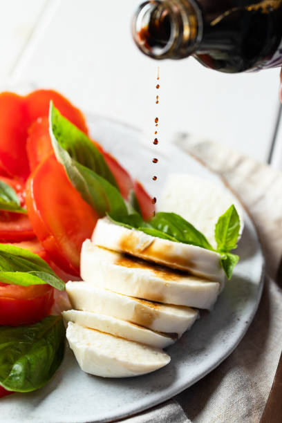 verter salsa balsámica en el. plato típico italiano - caprese salad salad restaurant vinegar fotografías e imágenes de stock