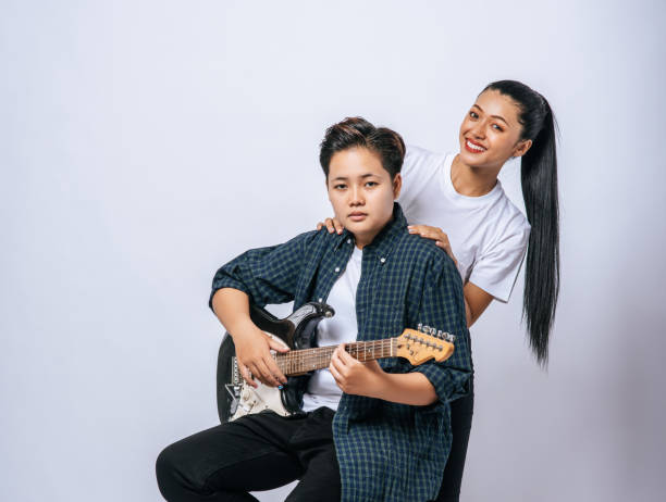 istock Two young women sat on a chair and played guitar. 1432736745