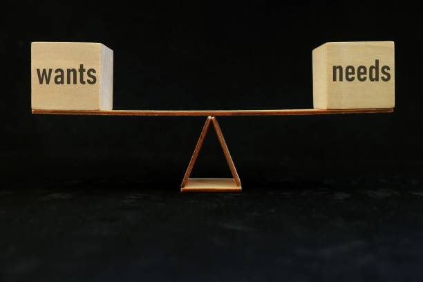 istock Balancing wants versus needs concept. Seesaw in dark black background. 1432744788