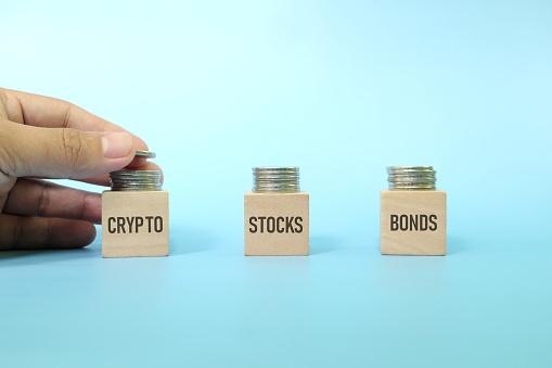 Investment asset allocation and diversification and risk management strategy concept. Hand stacking coins on multiple risk.