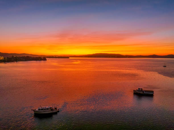 istock Aerial sunrise waterscape with boats and high cloud 1432747294
