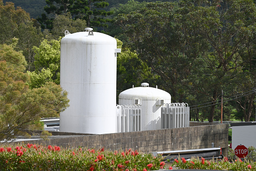 Two large white oxygen cylinders in a hospital yard